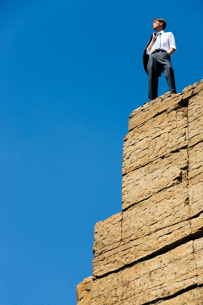Man op een bergtop met uitzicht over de horizon, symbool voor strategie, visie en leiderschap bij PACER.