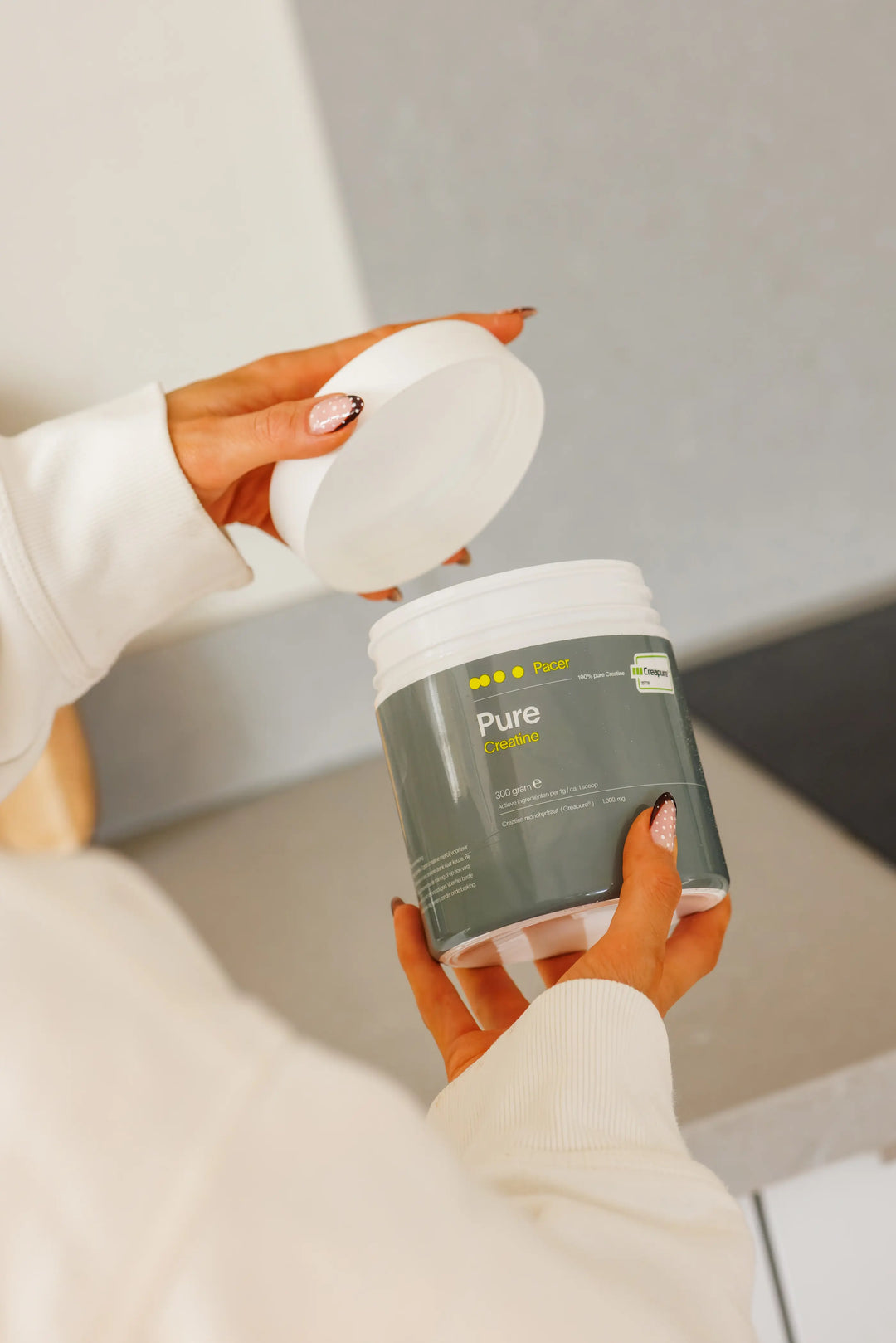 Sporter opent de pot PACER PURE creatine met Creapure®